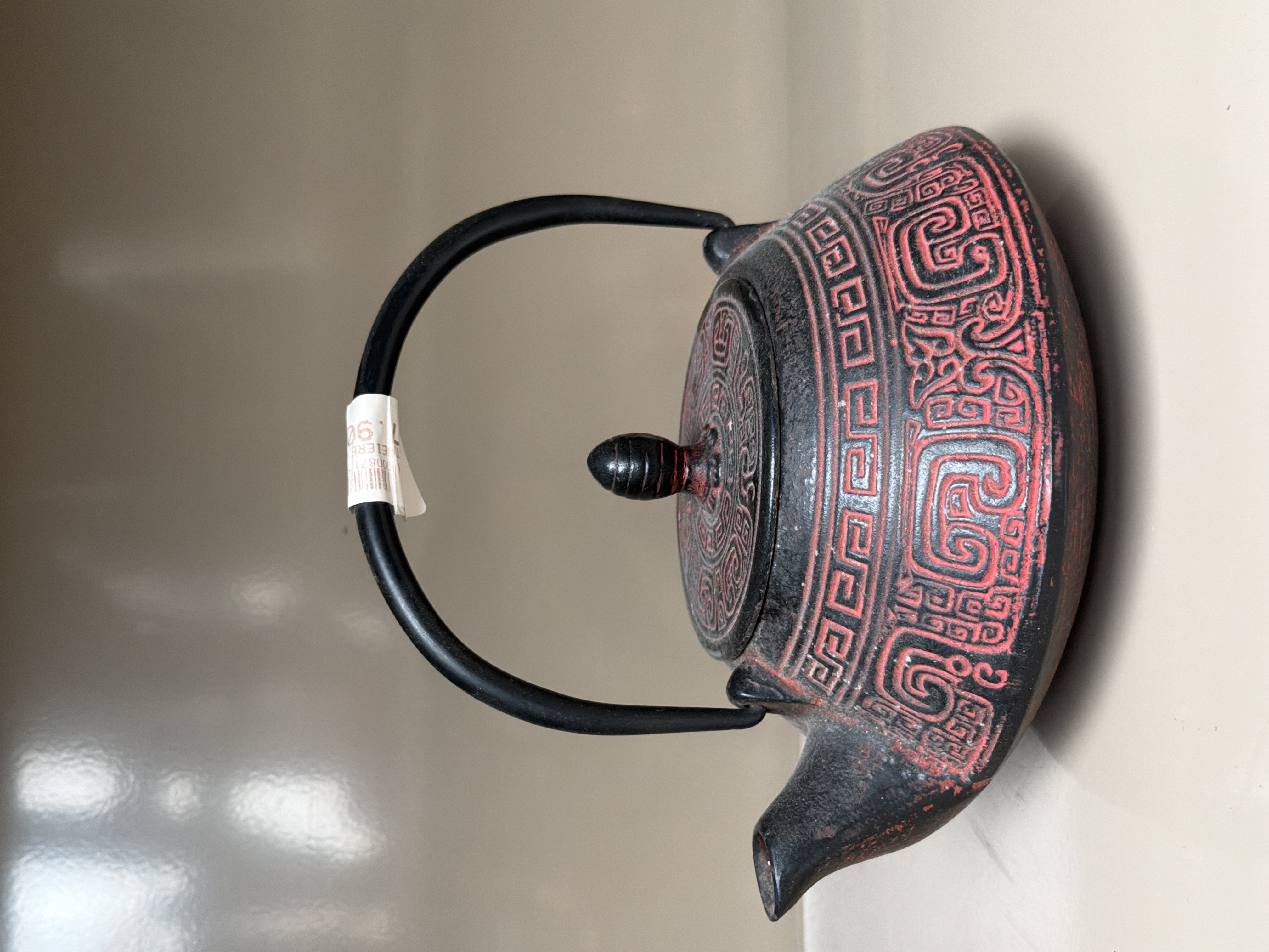 Théière en fonte rouge et noire à motifs géométriques