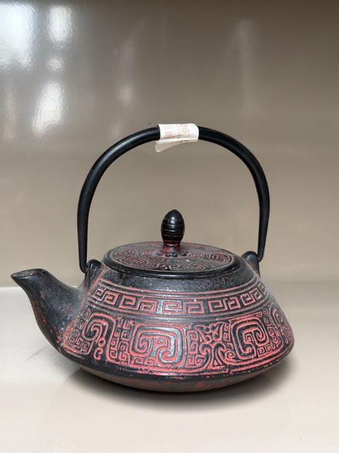 Théière en fonte rouge et noire à motifs géométriques