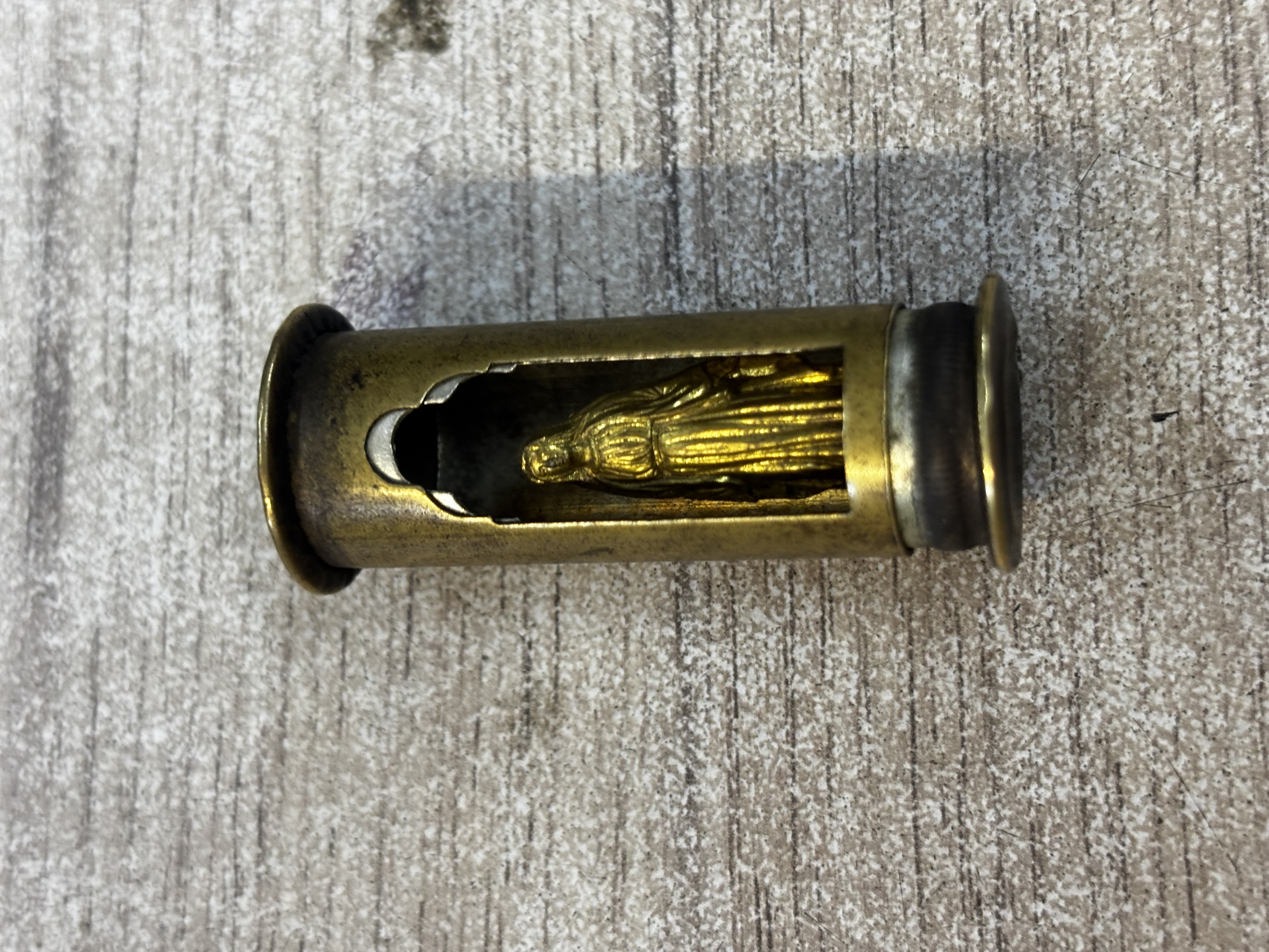 Objet cylindrique en laiton avec figurine religieuse